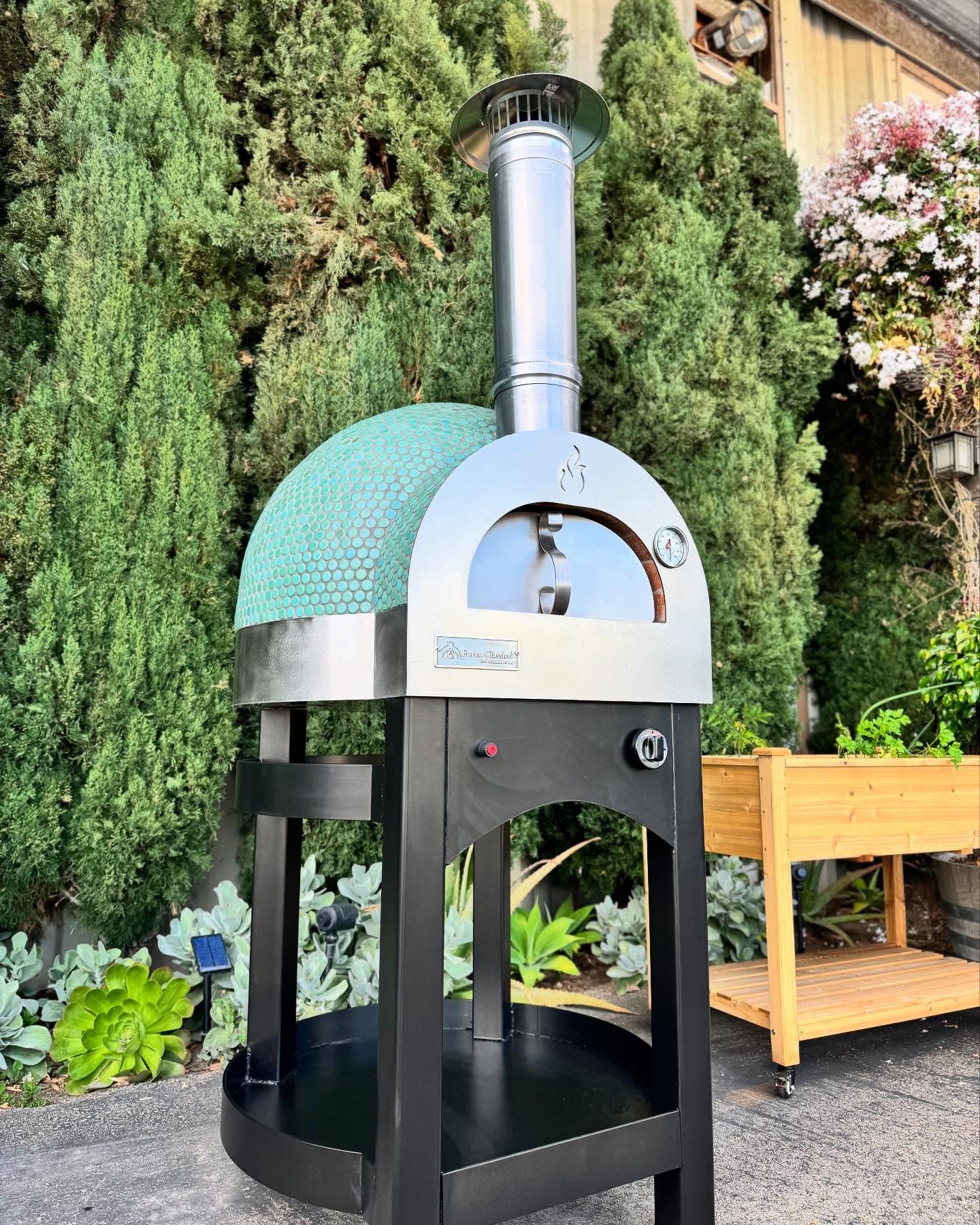 Forno Classico Piccolo 65 pizza oven with green dome in a garden setting