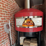 Forno Classico outdoor pizza oven with flames inside, mounted on a brick wall.