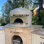 Forno Classico pizza oven with stone base in a garden setting