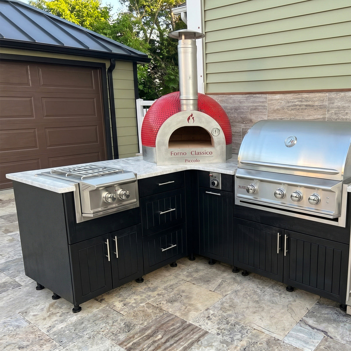 Outdoor kitchen with a Forno Classico Piccolo 65 pizza oven and grill on a patio